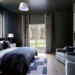 Dark blue-gray bedroom with navy bedding, patterned curtains, and a small sitting area
