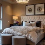 Neutral bedroom with taupe walls, cream tufted bed, layered bedding, dark accent pillows, and a patterned rug