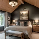 bedroom with a vaulted wood ceiling, dark accent wall, paired bedside lamps, nightstands, and an upholstered bench