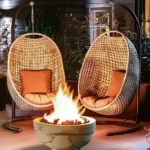 backyard patio with two egg chairs and a small round propane fire pit