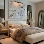 Simple modern bedroom with a low-profile upholstered bed, wood nightstand, large abstract artwork and an arched mirror