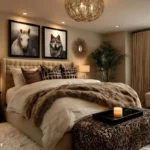 Bedroom with an upholstered bed, layered neutral bedding, faux fur throw, framed animal art, leopard bench, warm lamps, and a window seat