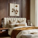 Cream upholstered bed with layered bedding, walnut nightstands, glass lamps, a wood slat wall, and a cushioned bench