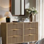 dresser with mirror above it across from bed