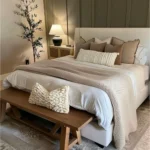 guest bedroom with bed pillows bench lamp on nightstand next to bed