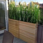 patio rule of 3 privacy tall wood outdoor planters with tall greenery in them on patio
